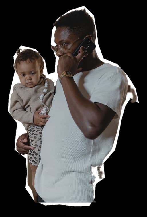 A father holding his baby, taking a call