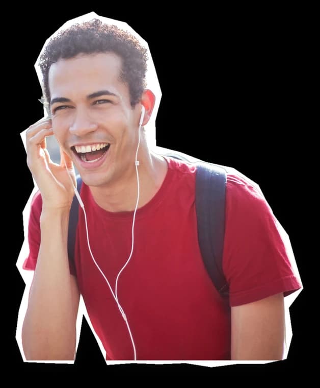 A young man laughing on the phone, out on the street